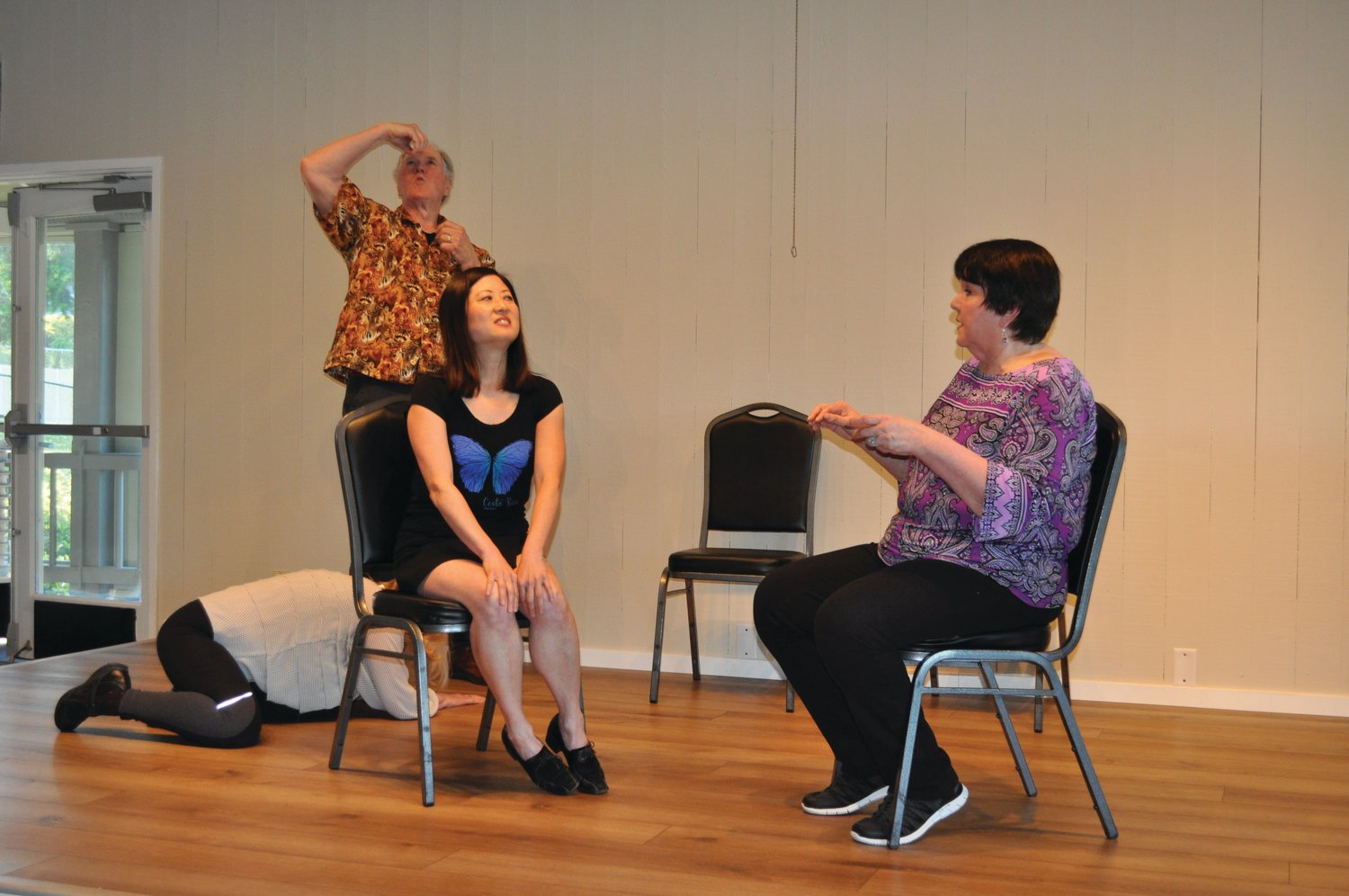 Madelyn Curll (floor), David Johnson, Karen Ni, and Nancy Peterson play “Fortune Teller,” a guessing game in which Peterson, the fortune teller, predicts future events in Ni’s life as suggested by the audience and conveyed by the two spirits, Curll and Johnson.